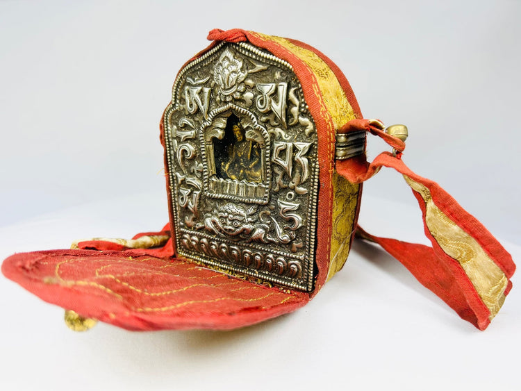 Himalayan Buddhist Gau shrine with repoussé decoration and original red fabric strap
