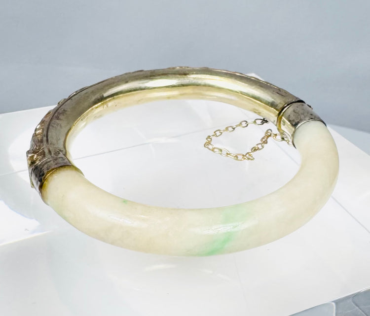 Chinese jade or hardstone bangle with chased silver mounts and aged patina