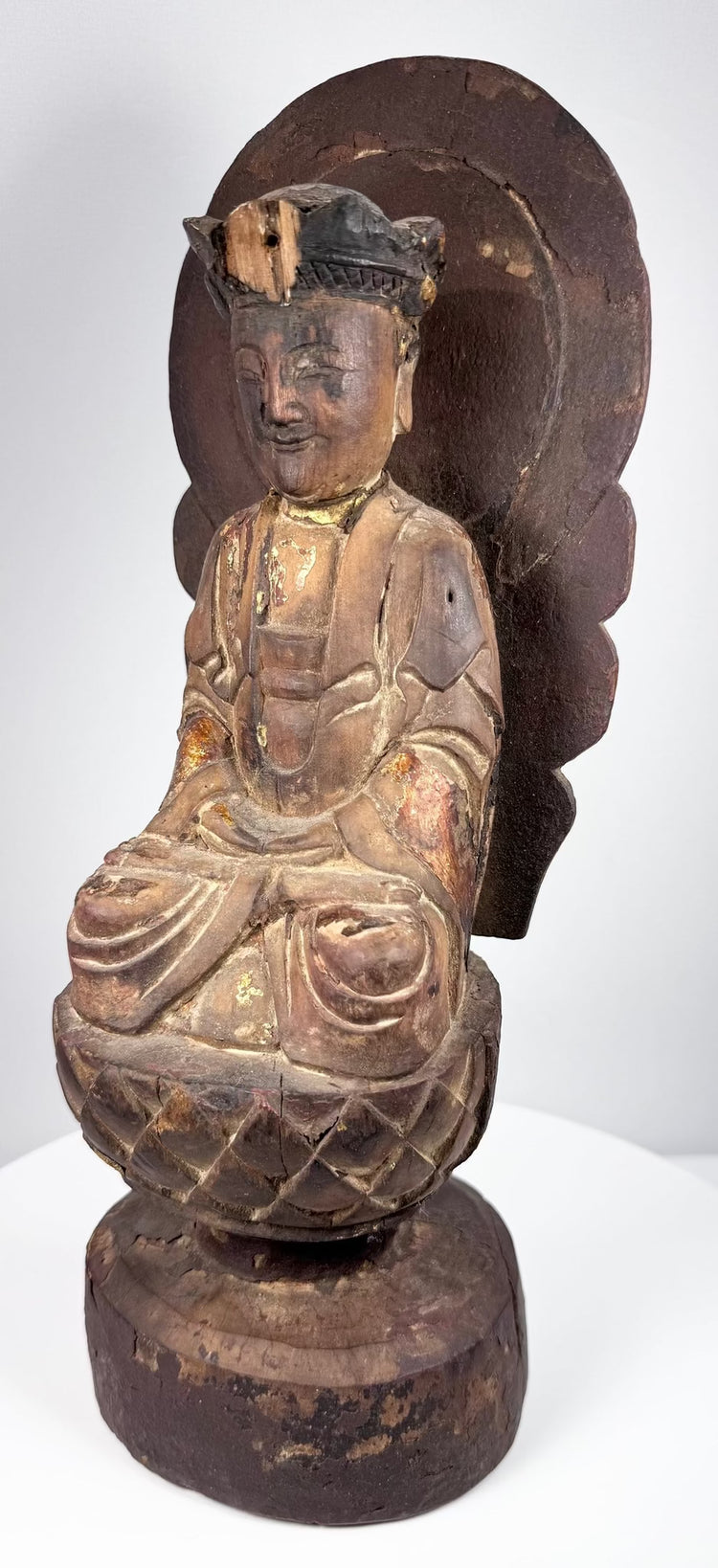 Antique Chinese devotional sculpture of Guanyin seated upon a carved lotus pedestal with aged lacquer and gilt decoration