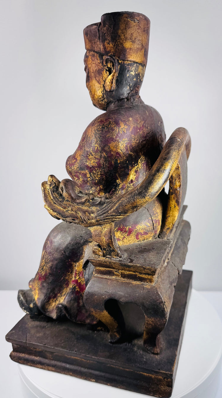 Side view of antique Chinese seated official figure showing carved throne structure, robes and stepped wooden base