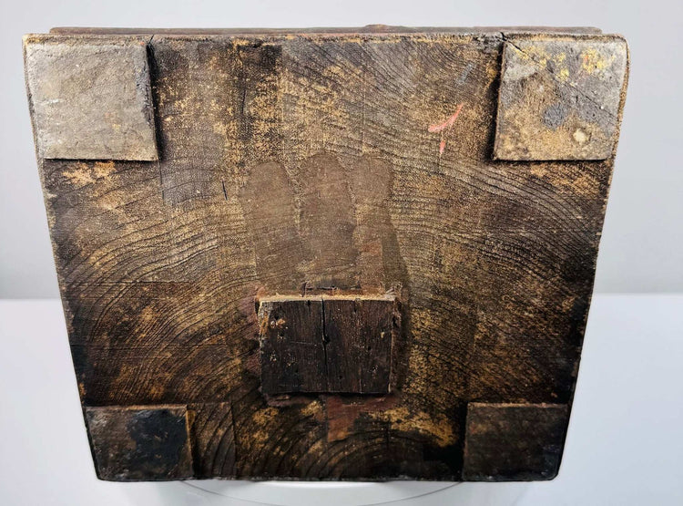 Close-up of dark wooden base with grain, corner blocks, and red mark on antique Chinese statue