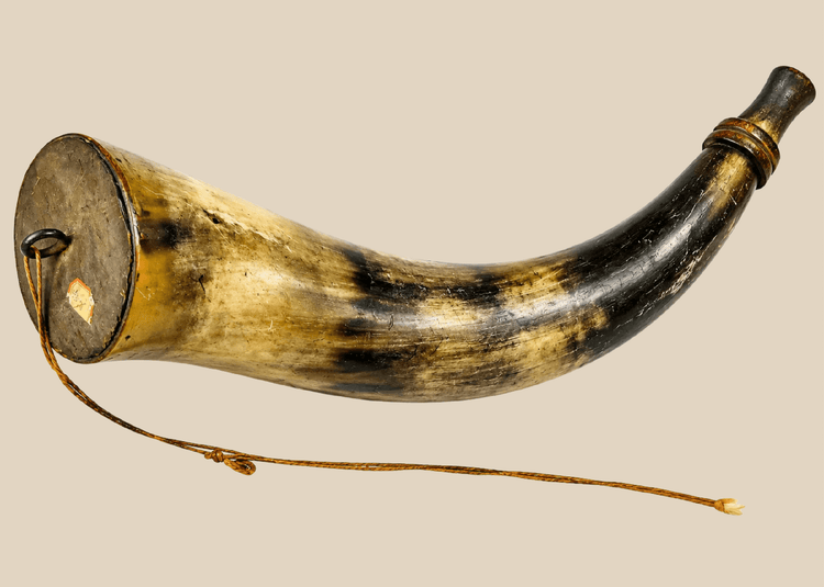 Antique powder horn displaying rich honey and olive-toned surface patina