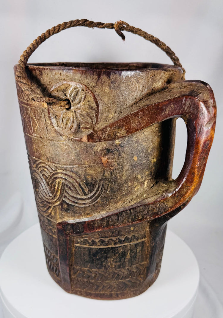 Traditional Tibetan or Nepalese hardwood container featuring hand-carved decorative bands