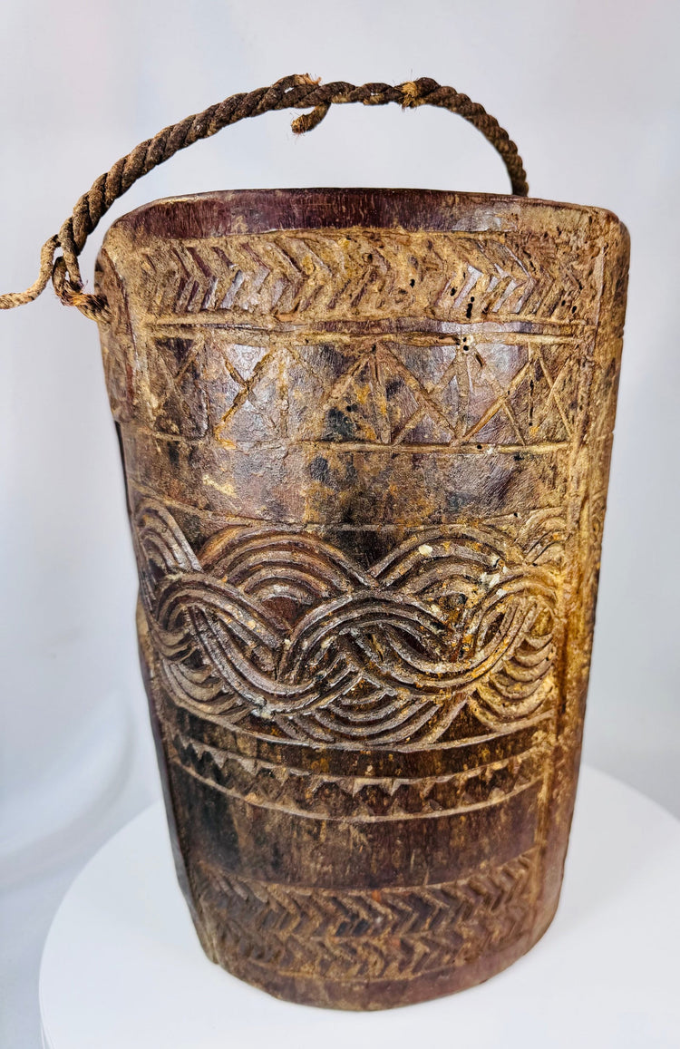 Himalayan folk art vessel featuring deep relief carving and sculptural carrying handle