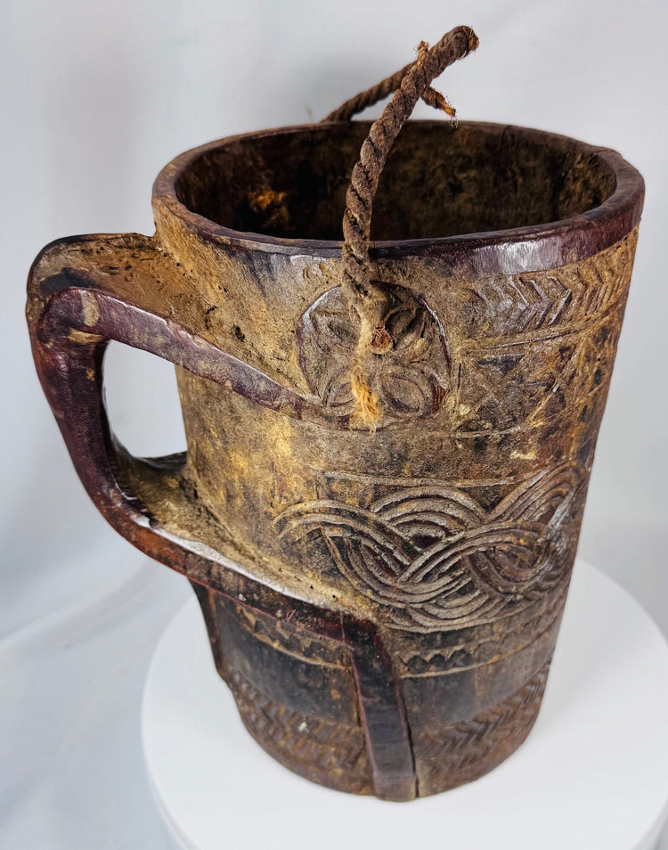 Hand-carved Himalayan wooden vessel with integrated handle and fiber suspension cord
