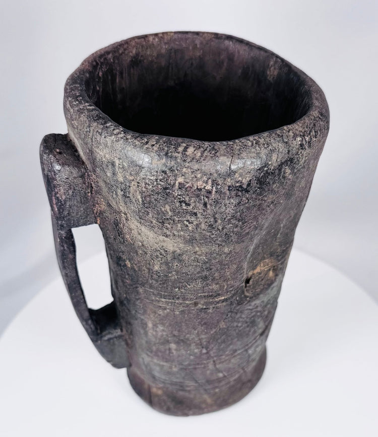 Rustic Tibetan carved hardwood container with integral handle and aged utilitarian surface