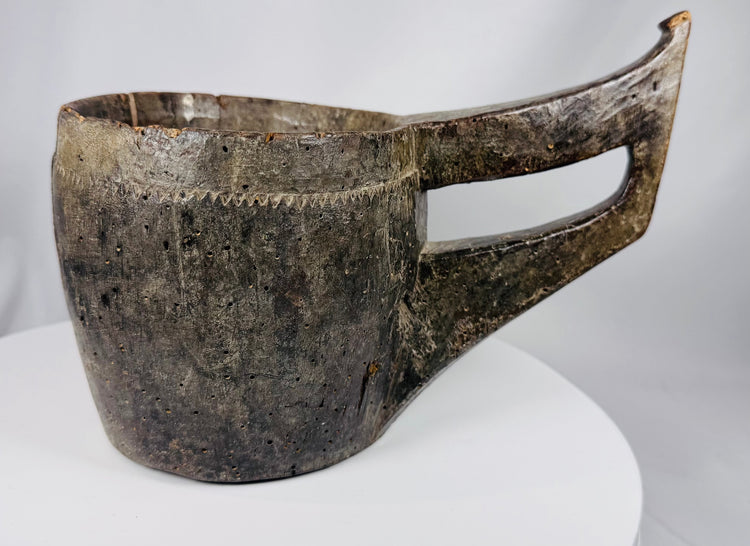 Hand-carved wooden vessel from Nepal or Tibet featuring a deep basin and curved handle