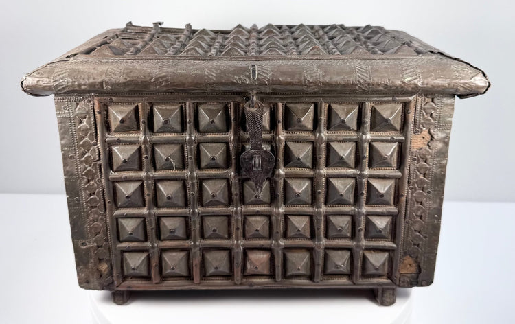 Front view of antique brass-clad wooden box with geometric embossing and key latch
