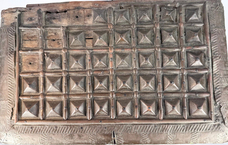 Close-up of the lid of a late 19th-century Indian hardwood box, showing rows of raised pyramid-shaped brass panels, geometric border decoration, exposed wood sections, and aged surface patina.