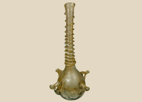Ancient Islamic glass vessel with ribbed neck and applied handles, translucent green hue, circa 9th–12th century CE.
