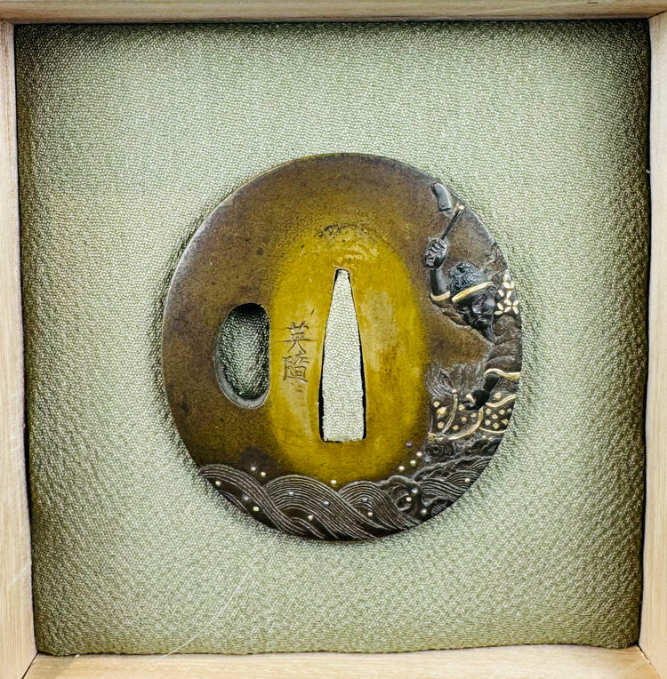 Signed Eizui Japanese sword guard displayed in fitted wooden collector’s box with textile-covered cushion