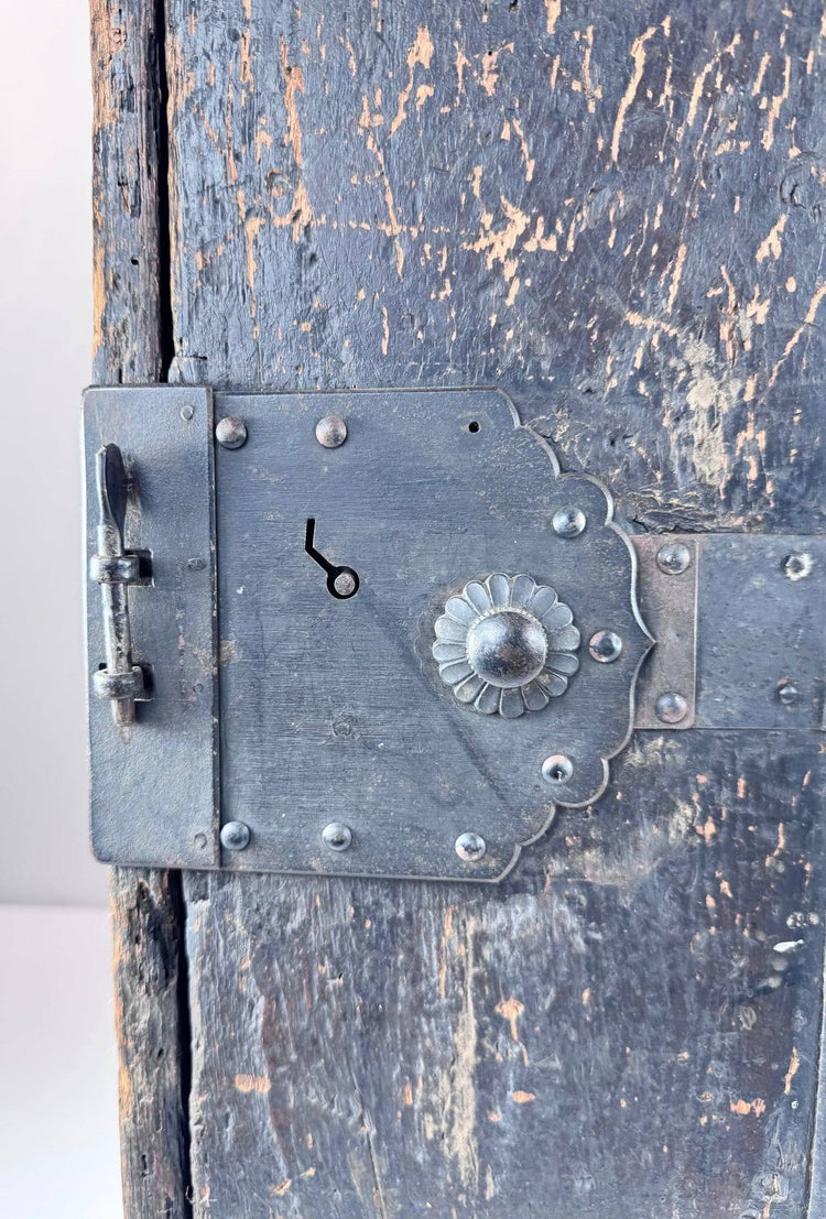 Close-up of Japanese ship chest front showing chrysanthemum-form lock fitting, riveted ironwork and hand-forged hardware