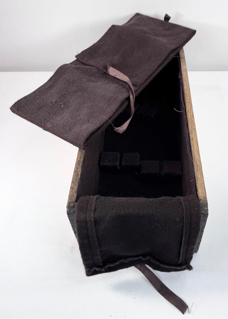 Angled view of silver-storage drawer with removable textile insert lifted to reveal the underlying wooden compartment