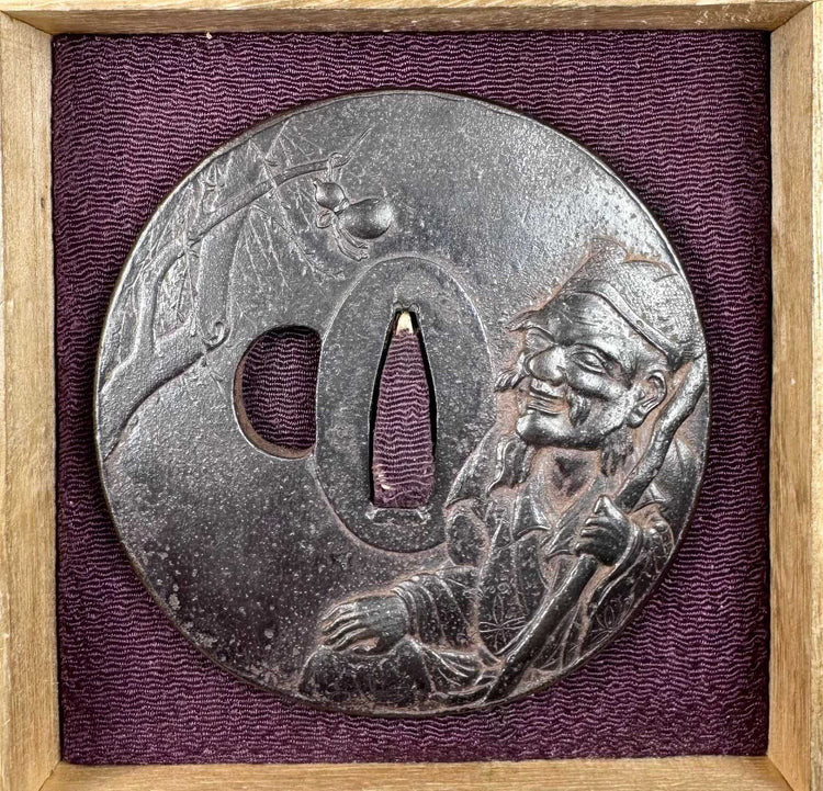 Edo–Meiji Japanese tsuba displayed inside a fitted wooden box with deep purple textile lining