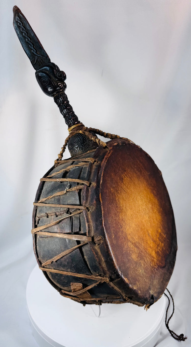 Himalayan shaman's drum from Nepal displaying extensive rawhide bindings and traditional ceremonial craftsmanship.