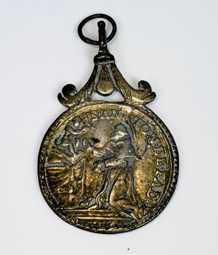 Obverse of an antique Catholic medal showing Saint Anthony of Padua receiving a vision of the infant Jesus.