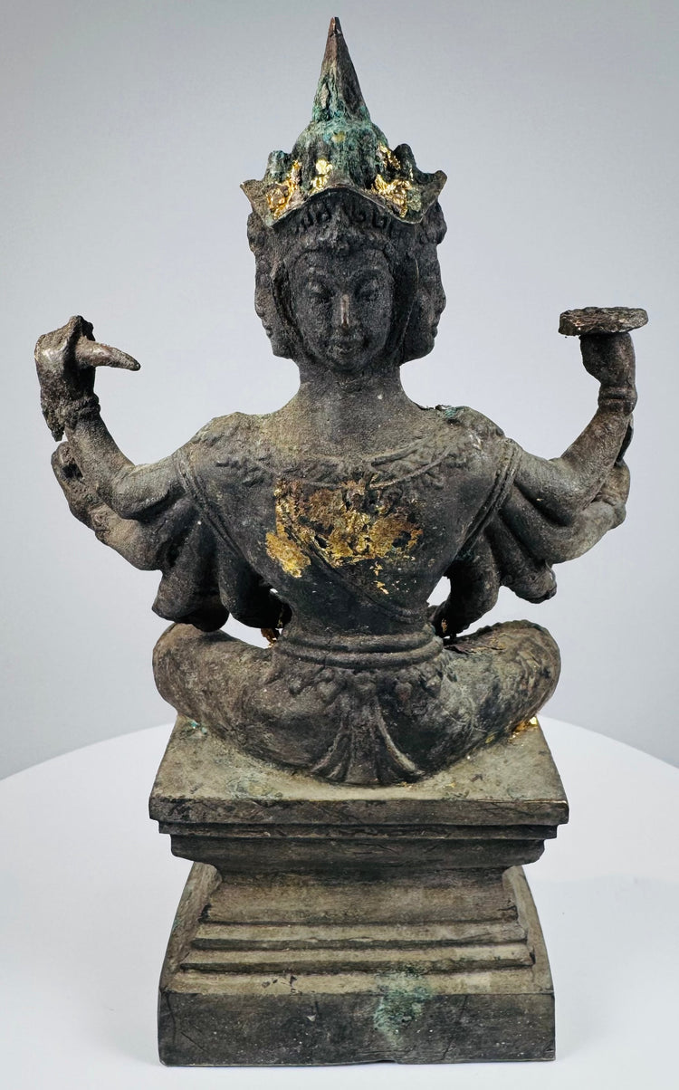 Rear three-quarter view showing the four faces and elaborate pointed headdress
