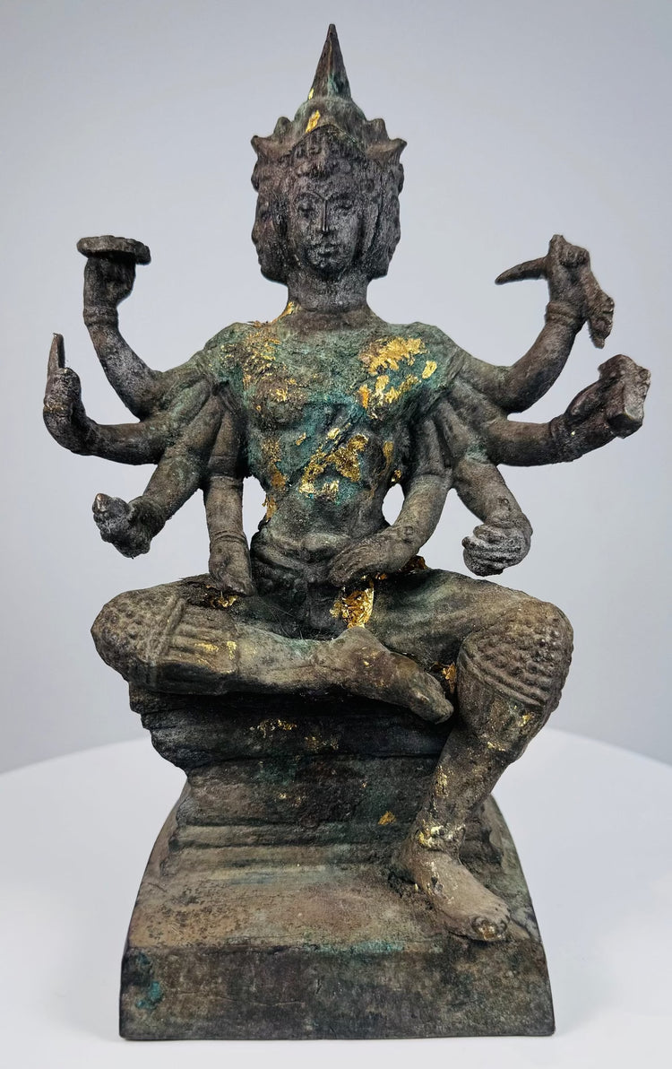 Three-quarter view of the antique Thai bronze deity with ritual attributes