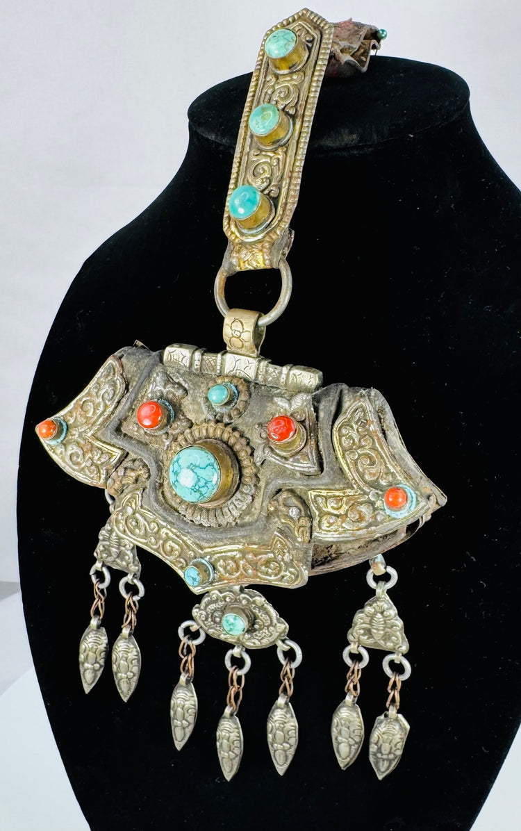 Traditional Tibetan portable shrine ornament with repoussé metalwork, turquoise, coral, and articulated hanging pendants.