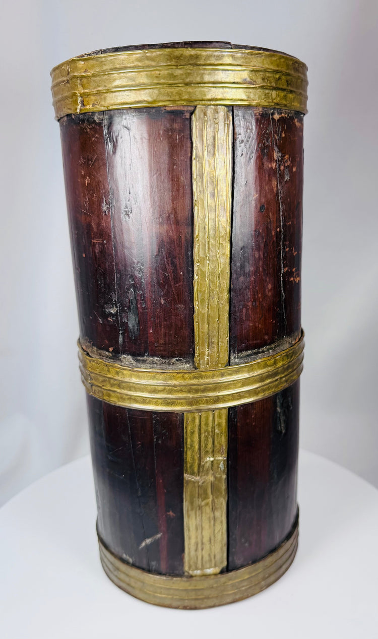 Traditional Tibetan household vessel with coopered wood construction and decorative brass bands.