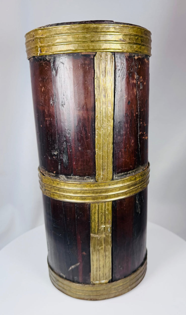 Traditional Tibetan household vessel with coopered wood construction and decorative brass bands.