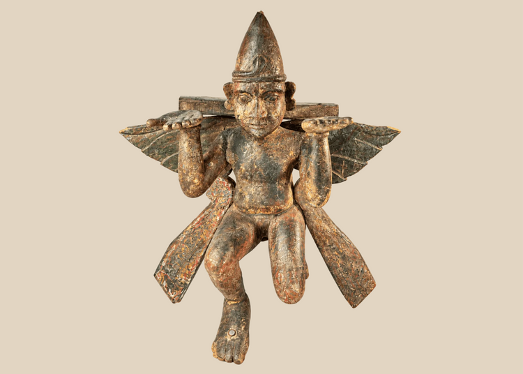 Antique hand-carved wooden winged temple guardian figure on display against a white background.