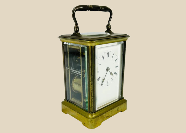 Elegant antique French brass carriage clock with beveled glass panels, white enamel dial with Roman numerals, and visible escapement through the top panel, stamped with a “B” in a circle attributed to Jules Bunelot, circa late 19th century.