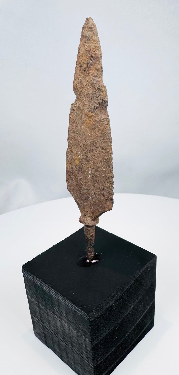 Broad tanged iron weapon point with heavy oxidation and mineral encrustation