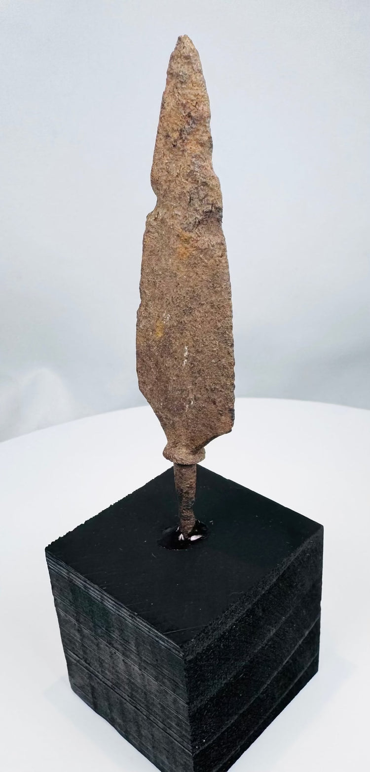 Broad tanged iron weapon point with heavy oxidation and mineral encrustation
