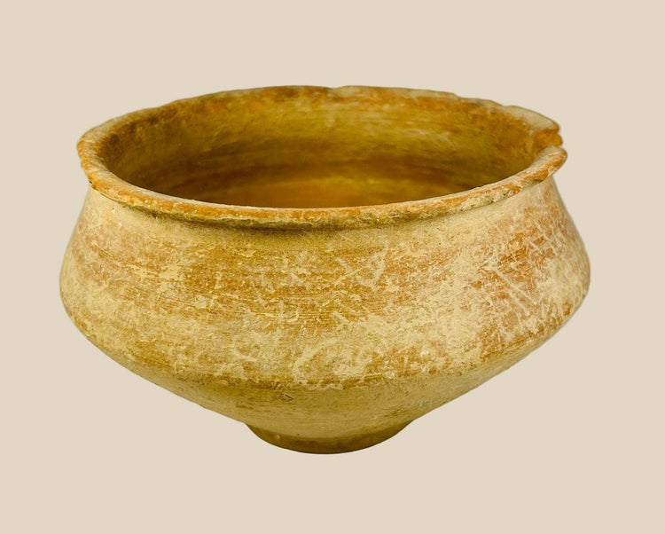 Ancient Bronze Age terracotta bowl, circa 2000–1500 BCE, from the Middle East or Asia; wide-rimmed vessel with rounded body and tapering base, hand-formed with earthy ochre surface and weathered patina, showing mineral deposits and age-related wear consistent with archaeological excavation.
