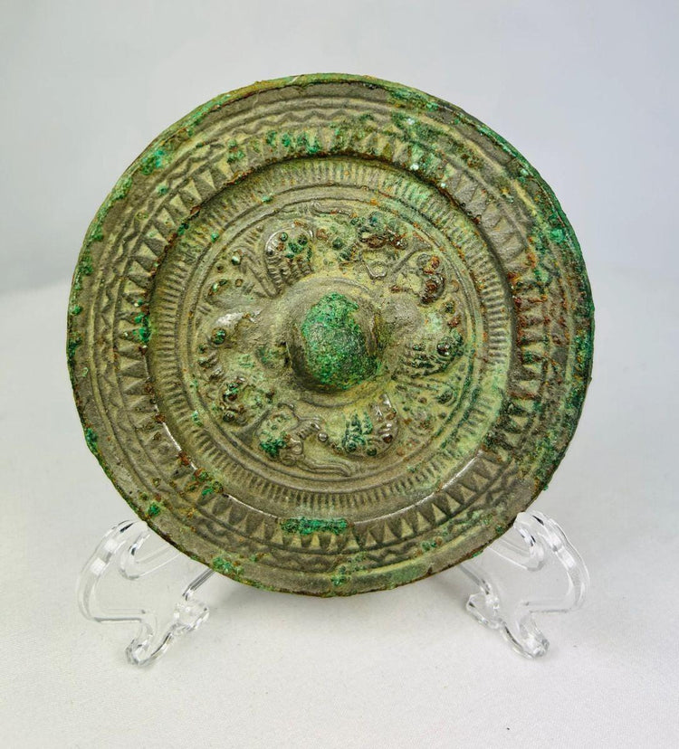 Han Dynasty bronze mirror, circa 206 BCE–220 CE, with engraved geometric and mythical motifs, central suspension knob, and rich green patina.