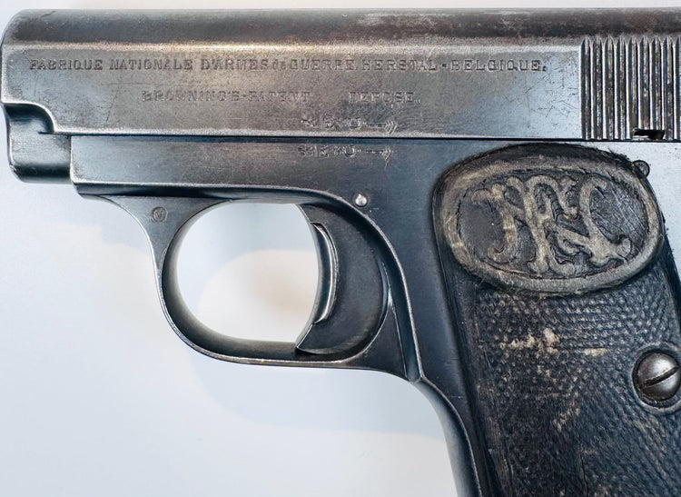 FN Browning Model 1906 displaying stamped slide inscriptions above the curved trigger guard and worn checkered grip.