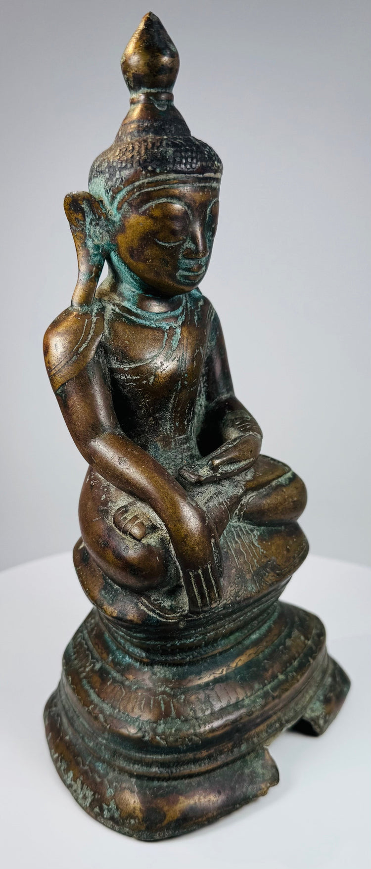 Three-quarter view of the Konbaung bronze Buddha with reddish-brown patina