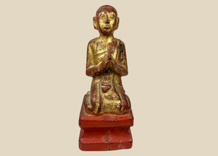 Hand-carved Burmese wooden monk statue, 18th–19th century, with gold leaf and red lacquer, kneeling in prayerful devotion.
