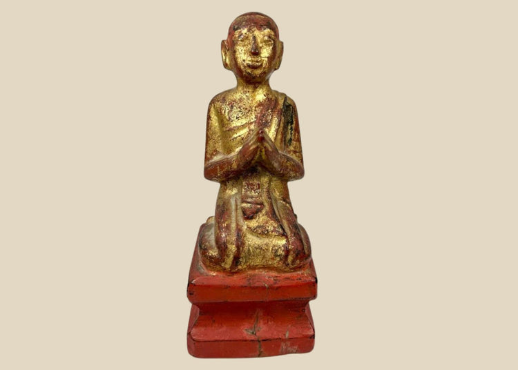 Hand-carved Burmese wooden monk statue, 18th–19th century, with gold leaf and red lacquer, kneeling in prayerful devotion.