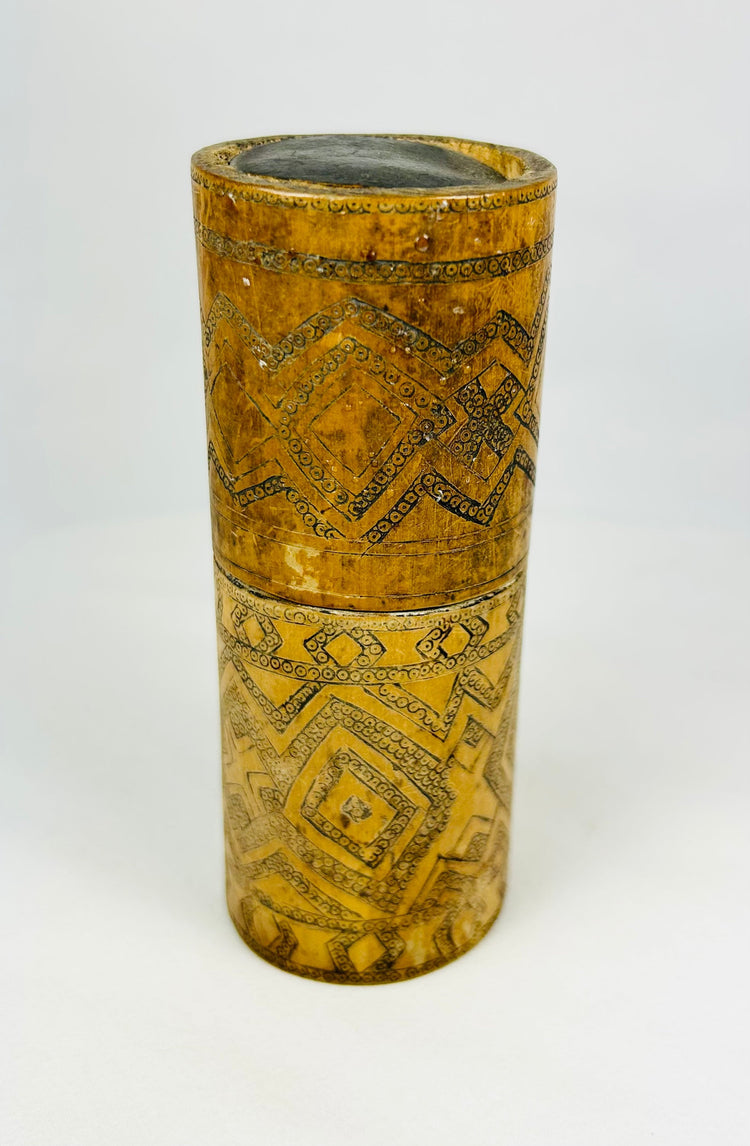 Carved bamboo storage container from Island Southeast Asia, photographed on white background