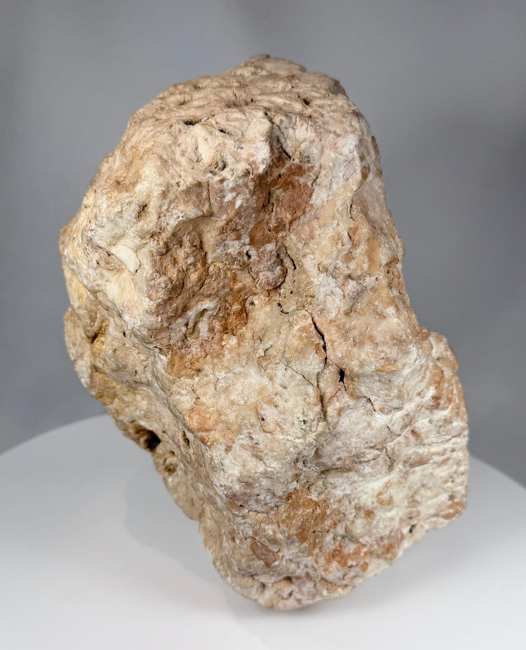 European medieval-style carved stone devotional fragment with cruciform figure and architectural background