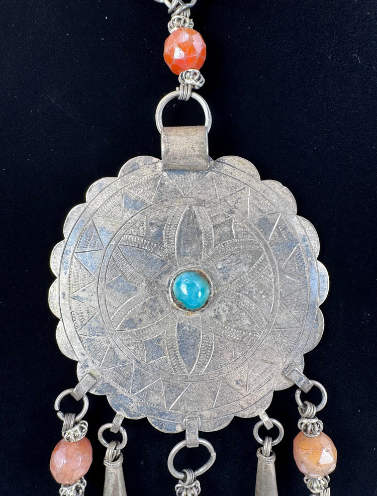 Close-up of six-petalled floral engraving on a large Afghan circular pendant