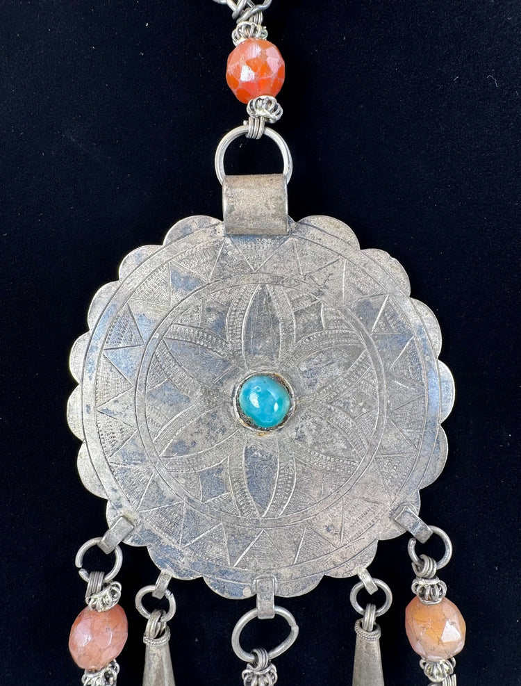 Close-up of six-petalled floral engraving on a large Afghan circular pendant