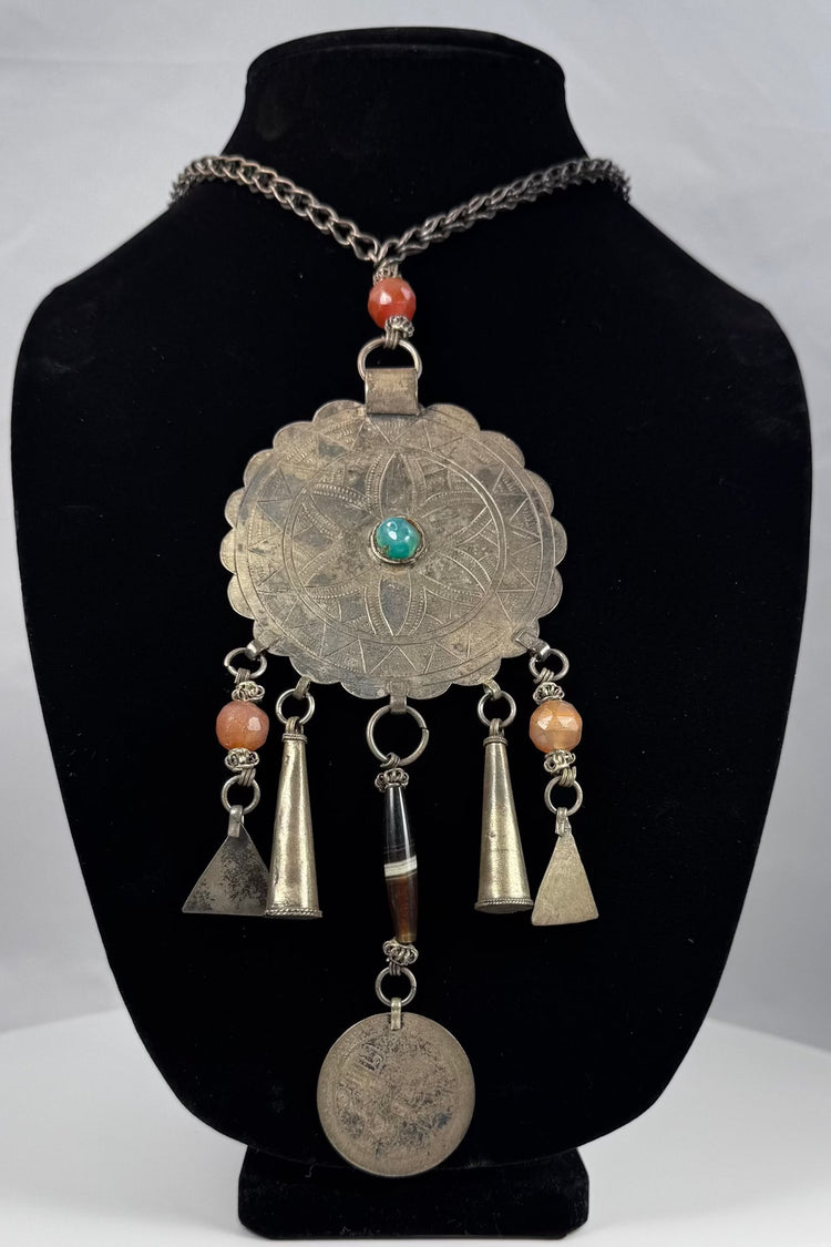 Large scalloped tribal pendant with punched borders and hand-fashioned suspension rings