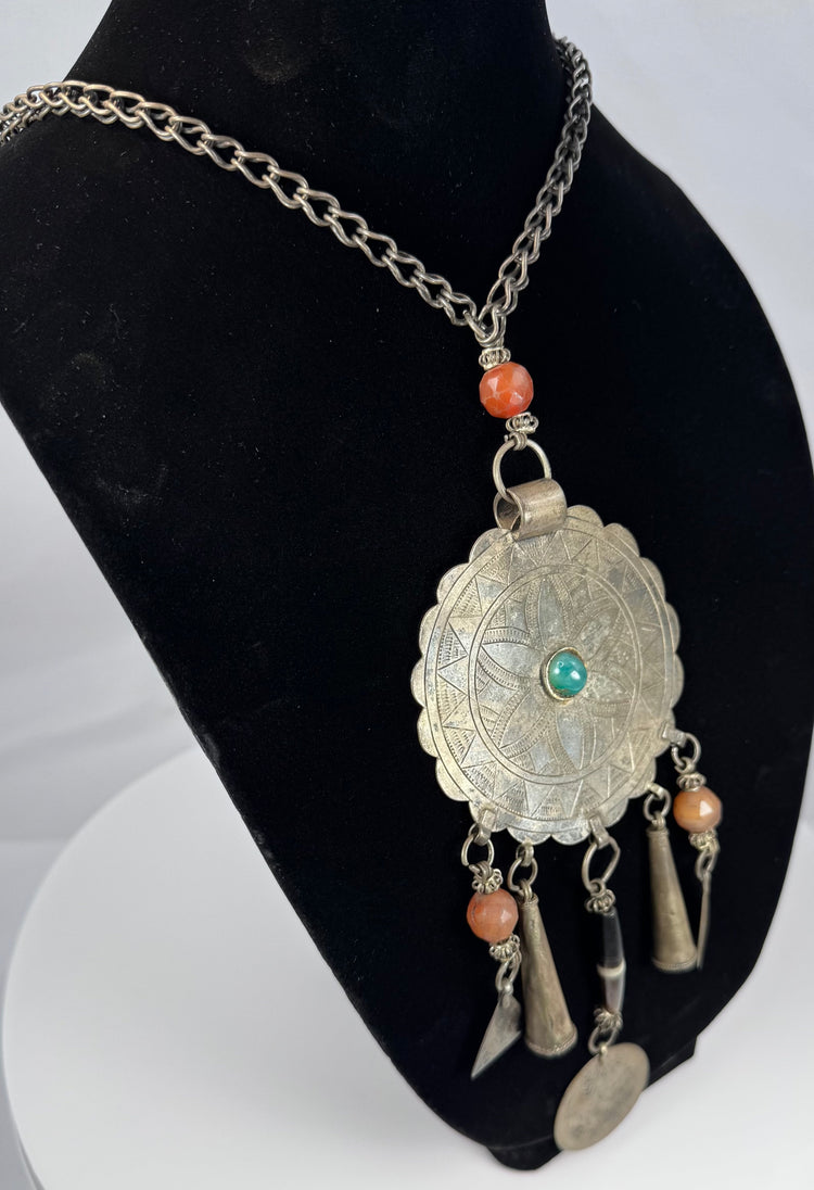 Reverse view of tribal metal pendant showing oxidation, rubbing, and handmade construction