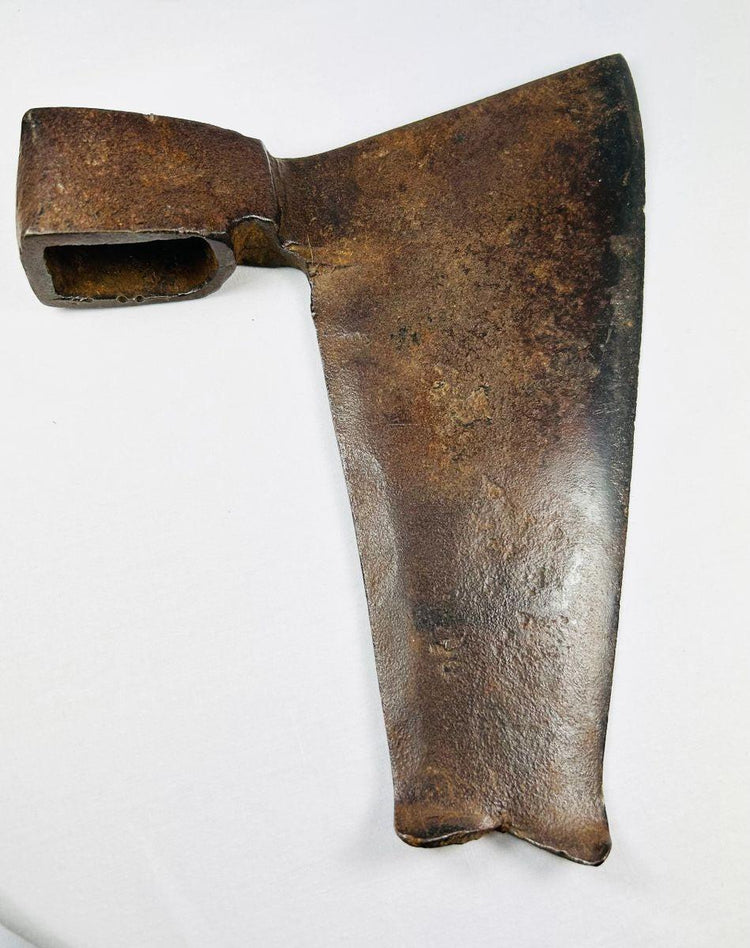 Close-up of rusty forged iron goosewing fishtail axe head with dark brown patina