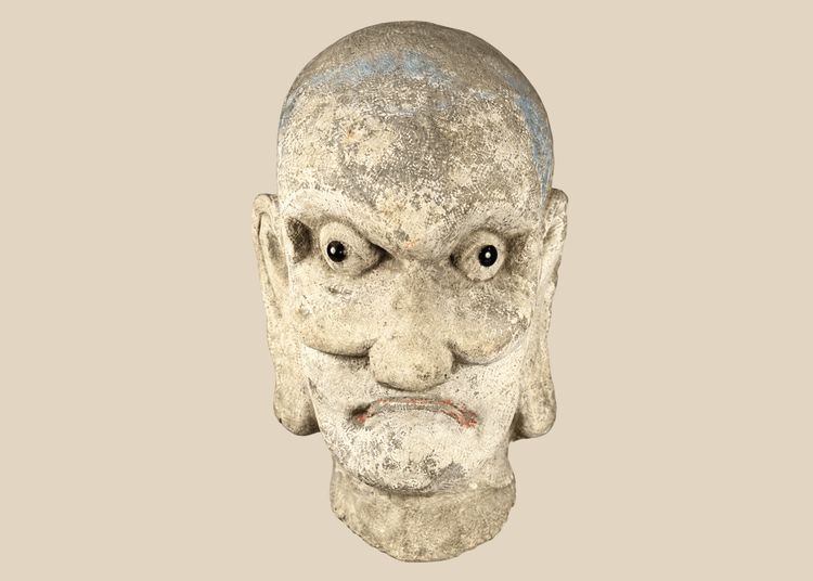 Qing Dynasty carved Chinese stone head of a Luohan with traces of original polychrome pigment.
