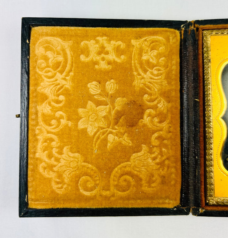 Victorian yellow velvet case lining with embossed floral scrollwork, ambrotype interior