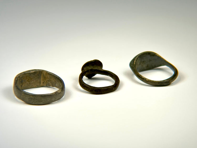 Ancient bronze finger ring collection showing three distinct bezel and band designs