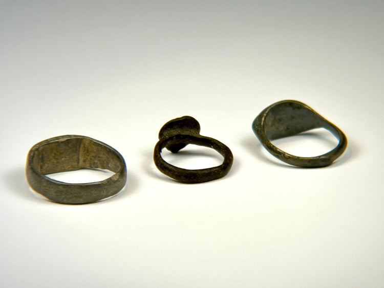 Ancient bronze finger ring collection showing three distinct bezel and band designs