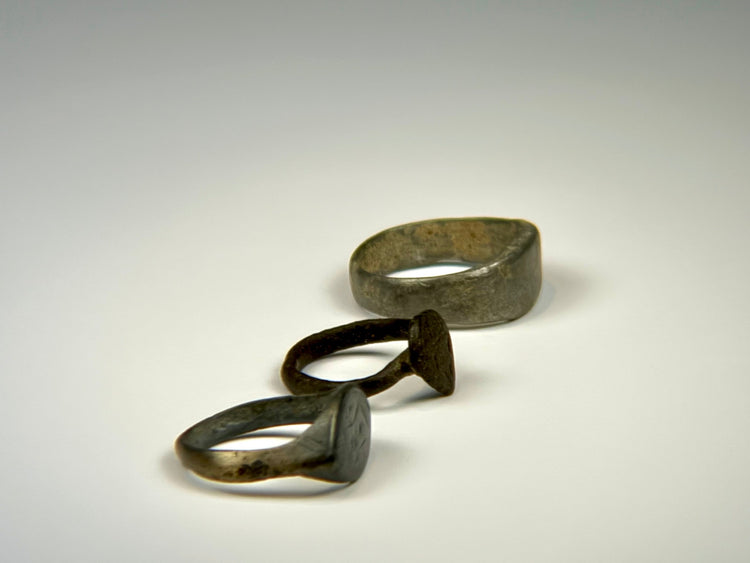 Ancient bronze ring with symbolic shield-form bezel, rounded band, and textured patina