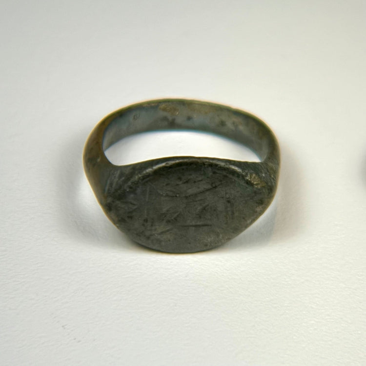 Ancient bronze oval signet ring with engraved bezel and deep olive patina, Roman to Early Medieval period