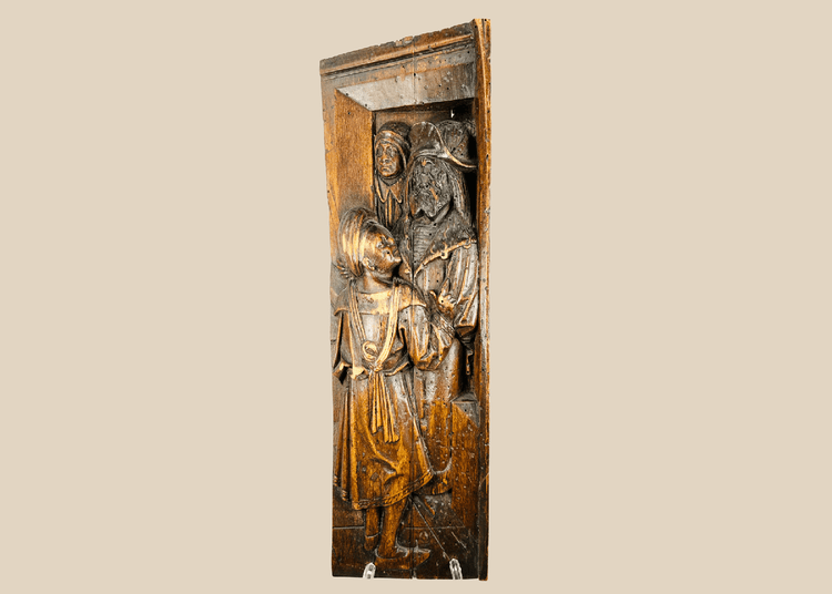 Front-facing view of antique Tudor carved oak panel with two robed figures in high relief.