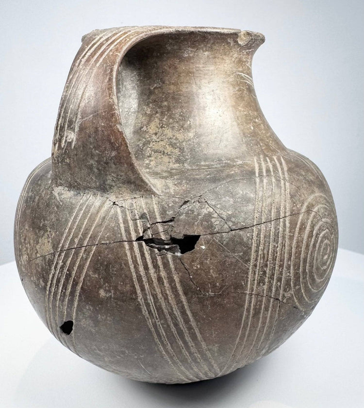 Side profile of damaged Early Etruscan amphora showing cracks and incised diagonal lines